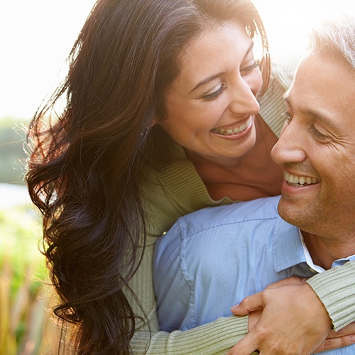 Middle-aged man and woman smiling together after a smile makeover