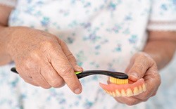 Woman brushing her dentures