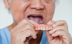 Woman putting in dentures