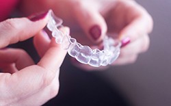 woman holding clear aligners 