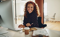 Woman smiling while sitting at desk in office