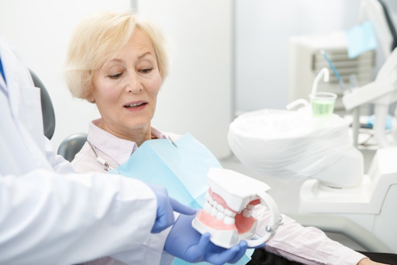 Older patient talking to dentist with their new dentures